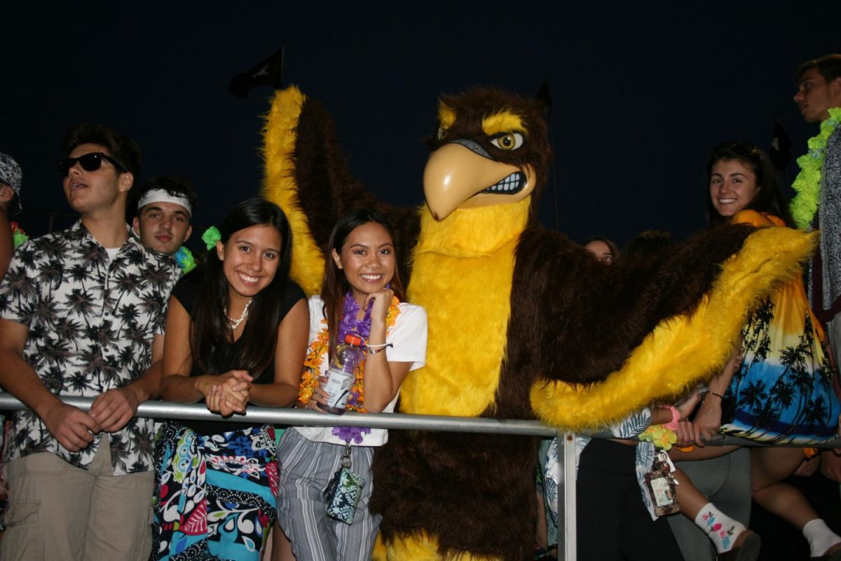 At+half+time%2C+seniors+pose+with+the+Falcon+Mascot.